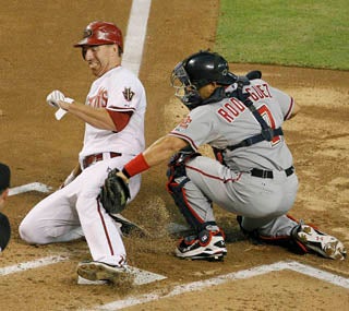 Adam LaRoche slides under Ivan Rodriguez's tag as the D-Backs double up the Nats.  (AP)