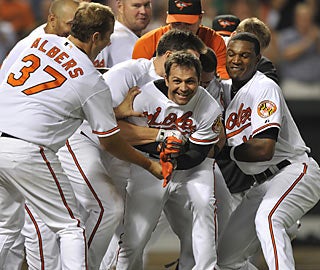 Teammates swarm Brian Roberts after the second baseman hits a rare home run in walk-off style.  (AP)