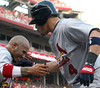Yadier Molina (4), who sparks a bench-clearing confrontation, is congratulated after his home run. (AP)