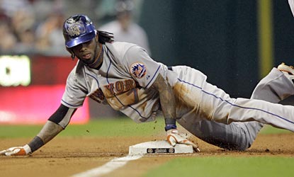 Jose Reyes slides safely into third with a triple, one of his season-high four hits on the night.  (AP)