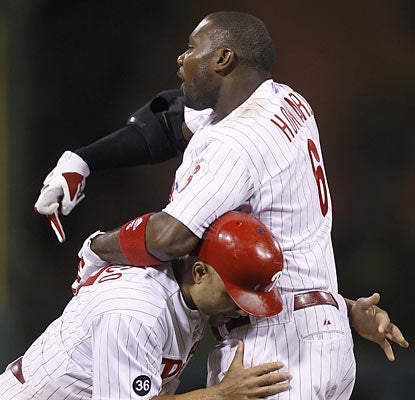 Placido Polanco restrains a heated Ryan Howard, who gets ejected in the 14th for tossing his equipment following a strikeout. (AP)
