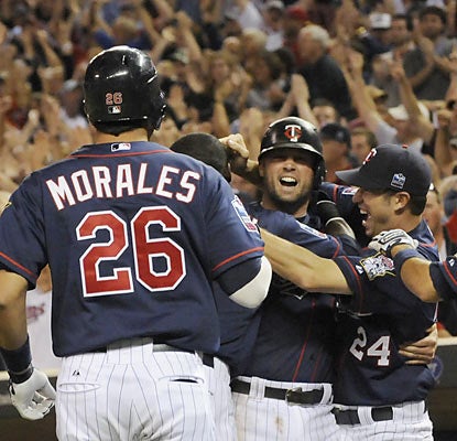 Michael Cuddyer (center) gets mobbed by teammates after he scores the winning run off a 10th-inning hit by Danny Valencia.  (AP)