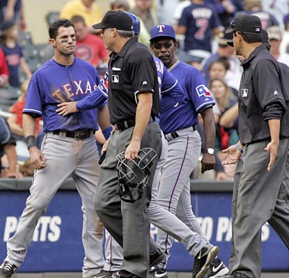 Michael Young is restrained as he argues a coach's interference call that results in the final out of the game.  (AP)