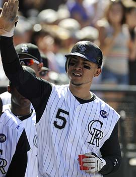 It's possible Carlos Gonzalez could high-five his way to the Triple Crown. (AP)