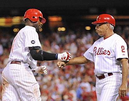 Ryan Howard gets props from third-base coach Sam Perlozzo after getting three of his six RBI on a home run.  (US Presswire)