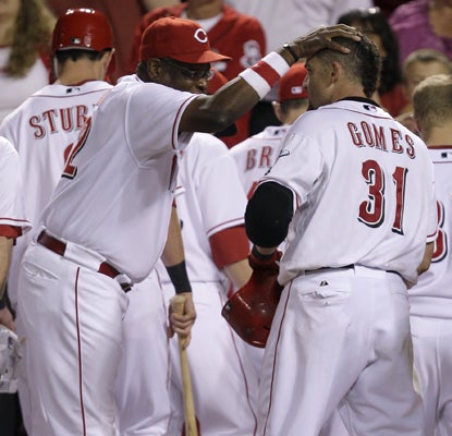 Dusty Baker rubs Jonny Gomes on the head after Gomes drives in the winning run in the 12th inning against the Pirates. (AP)