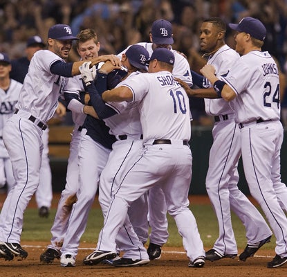 Willy Aybar is swarmed by his teammates after hitting the game-winning grounder in the 10th.  (AP)