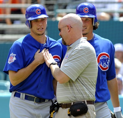 The Cubs' medical trainer checks Tyler Colvin after he was struck by a broken bat during the second inning. (AP)