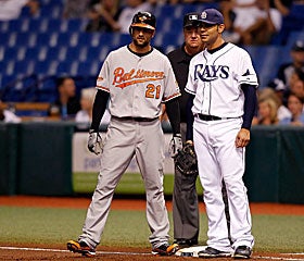 Baltimore's Nick Markakis and the Rays' Carlos Pena chat at first base before dozens in Tampa. (Getty Images)