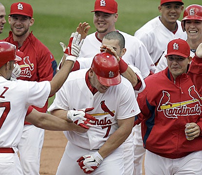 Matt Holliday is mobbed by his teammates after hitting a walk-off RBI single in the 11th inning (AP)