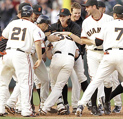 Aaron Rowand is mobbed by his Giants teammates near second base after driving in the game-winning run in the 12th inning. (AP)