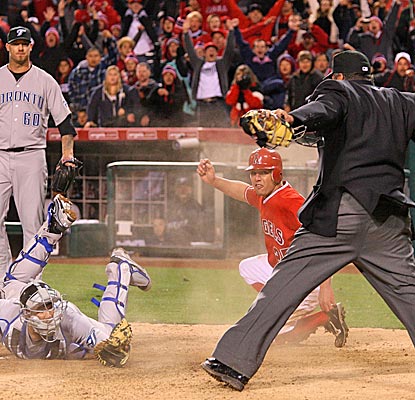 The Angels' Peter Bourjos slides in safely ahead of the tag of Blue Jays catcher J.P. Arencibia for the game-winning run. (US Presswire)