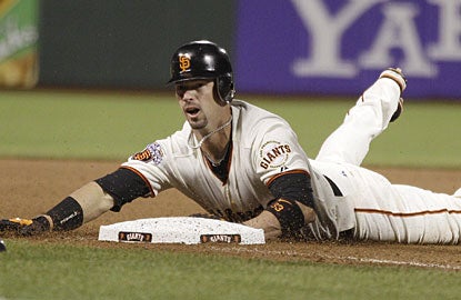 Aaron Rowand slides in safely at third base for a triple before scoring the tiebreaking run for San Francisco. (AP)