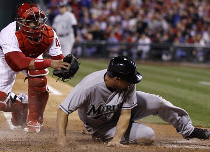 Gaby Sanchez avoids the tag to score on a two-RBI single from Greg Dobbs as the Marlins beat the Phillies. (AP)