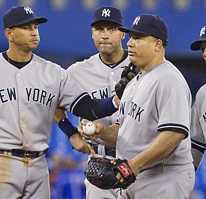 Yankees pitcher Bartolo Colon gets a pat on the back from his teammates after going 6 2/3 innings in the Yankees' win.  (AP)