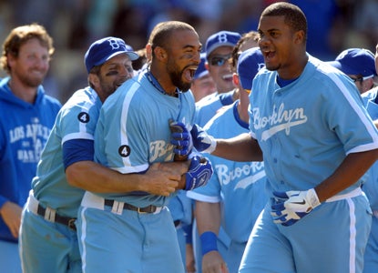 Matt Kemp is mobbed by teammates after hitting the game-winning home run against the Braves in the 12th inning. (US Presswire)