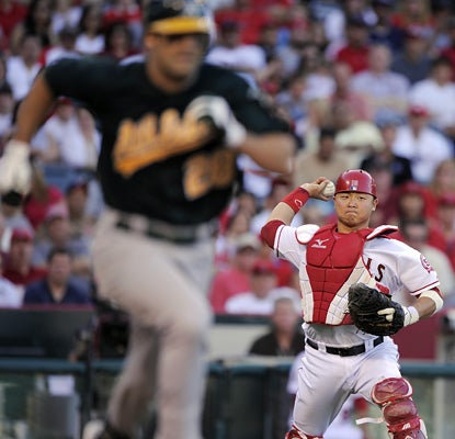 Catcher Hank Conger throws out Conor Jackson of the Athletics during the eighth inning of the Athletics' win.  (AP)