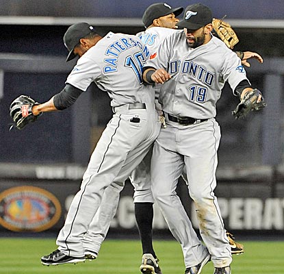 The Blue Jays' Corey Patterson, Rajai Davis and Jose Bautista celebrate a 5-3 win over the Yankees. (AP)