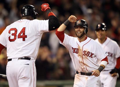 Dustin Pedroia (right) celebrates scoring a crucial run in the seventh on an Adrian Gonzalez RBI single.  (Getty Images)