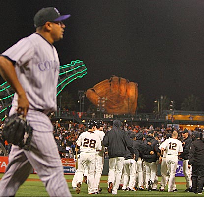 The Giants celebrate in front of Rockies relief pitcher Franklin Morales after Mike Fontenot's game-winning RBI.   (US Presswire)