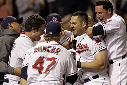 Travis Hafner is mobbed by teammates after his two-run homer with two outs in the ninth inning. (AP)