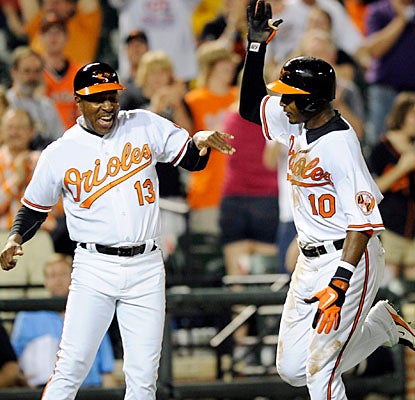 Adam Jones (right) celebrates his two-run walk-off homer with Orioles 3B coach Willie Randolph. (AP)