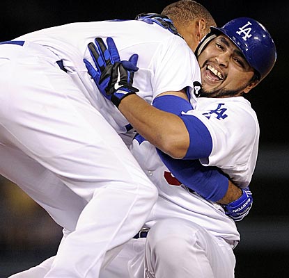 Dioner Navarro is tackled by Matt Kemp after the Dodgers catcher hits a single through a five-man infield to beat the Marlins.  (AP)