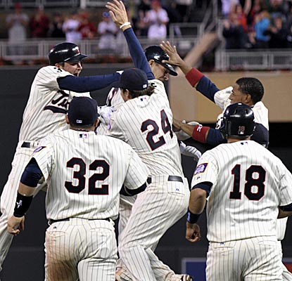 The Twins mob Danny Valencia after his bases-loaded single wins the game in the bottom of the 10th.  (AP)