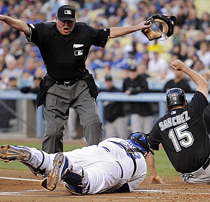 Gaby Sanchez is safe at home for the Marlins in a wild day at the ballpark in Los Angeles.  (AP)