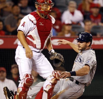 John Jason slides in safely after Reid Brignac lays down the squeeze bunt in the 10th inning.  (AP)