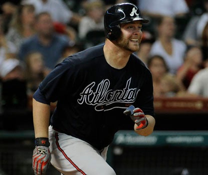 Brian McCann watches his three-run homer go over the fence in the 10th inning of Atlanta's victory. (AP)