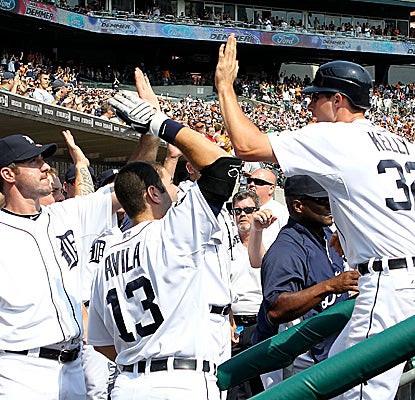 The Tigers celebrate in the dugout after Don Kelly scores on a Miguel Cabrera single in Detroit's big eighth inning. (Getty Images)