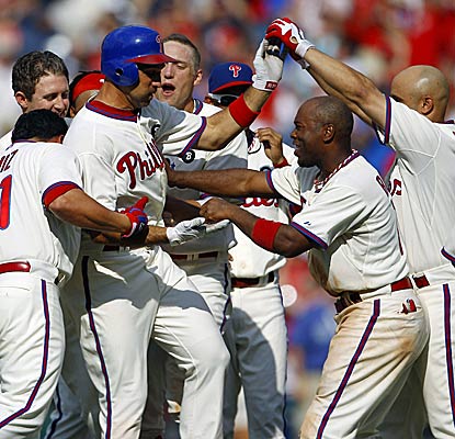 Teammates congratulate Raul Ibanez on his game-winning walk-off hit in the 10th inning as the Phillies sweep the Pirates. (AP)