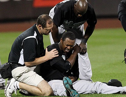 Hanley Ramirez is tended to by medical personnel after injuring his left shoulder diving for a ball. (US Presswire)