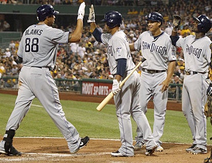 Kyle Blanks is cheered at the plate by his teammates after driving the ball out of the park for a grand slam. (AP)