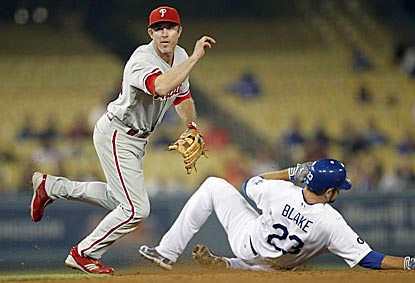 Despite Casey Blake's efforts, Chase Utley successfully pivots and completes a double play that ends the seventh inning.  (AP)