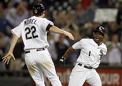 Brent Morel is among the first of Juan Pierre's teammates to reach him after he delivers his walk-off single.  (US Presswire)