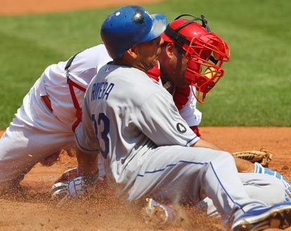 Juan Rivera has three RBI for the Dodgers, and scores as he slides past the tag of Cards catcher Gerald Laird. (Getty Images)