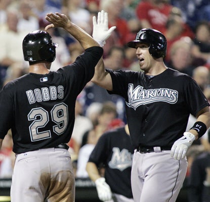 Florida's John Buck (right) is greeted by Gregg Dobbs after hitting a grand slam in the sixth inning against the Phillies. (AP)