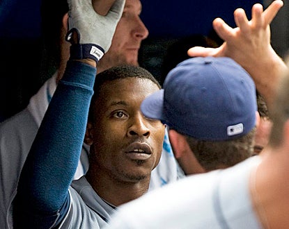 B.J. Upton receives congratulations in the Rays dugout after his three-run homer in the seventh inning. (AP)