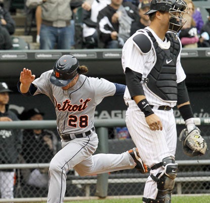 Will Rhymes touches home plate to account for the winning run that extends Detroit's win streak to 12.  (AP)