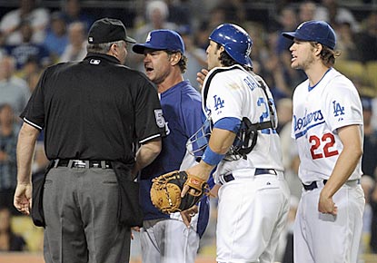 Dodgers manager Don Mattingly and catcher Rod Barajas plead Clayton Kershaw's case to home plate umpire Bill Welke.  (Getty Images)