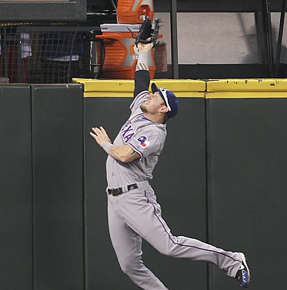 Texas left fielder Josh Hamilton leaps and takes a home run away from Seattle's Mike Carp in the eighth inning.  (Getty Images)