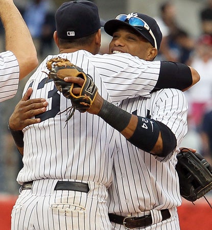 Alex Rodriguez (13) and Robinson Cano (24) celebrate after clinching a playoff berth. (AP)