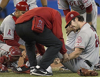 Dan Haren is tended to by an Angels trainer after being struck in the wrist by a shot from Eric Thames. (AP)