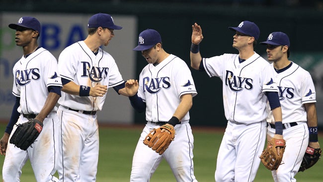 Evan Longoria (middle) and the Rays celebrate a much-needed win against the Yankees. (AP)