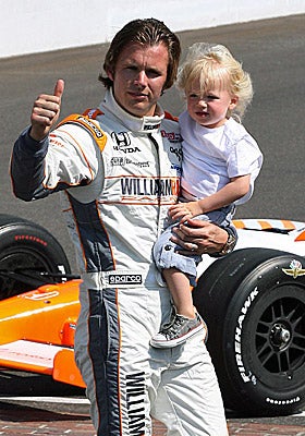 Dan Wheldon carries his son Sebastian after winning the 2011 Indy 500. (US Presswire)