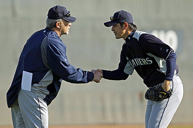 Pitching coach Carl Willis (left) talks with Hisashi Iwakuma as the Mariners kick off spring training. (AP)