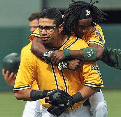 Kila Ka'aihue gets mobbed by a jubilant Jemile Weeks after his game-winning hit in the 14th against the White Sox. (US Presswire)