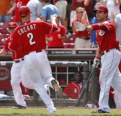 Zack Cozart comes home with the winning run in the 10th inning and gets a high-five from Joey Votto.  (US Presswire)